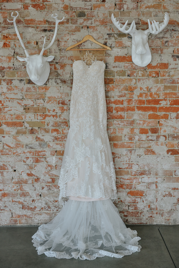Bridal Gown hanging on exposed brick wall